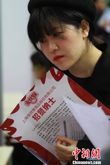 大学生在企业展台前咨询。　泱波 摄