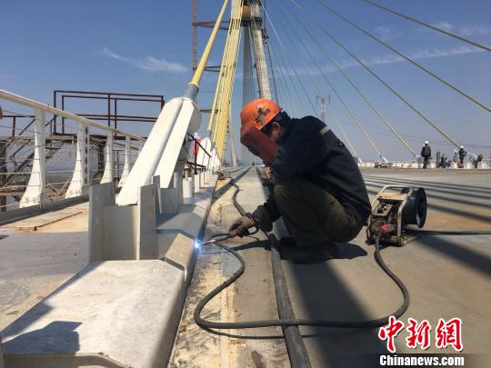 在大桥建设现场，几位工人正在桥面做焊接工作。　吴兰 摄