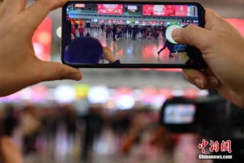 资料图：旅客用手机拍摄。/p中新社记者 刘忠俊 摄