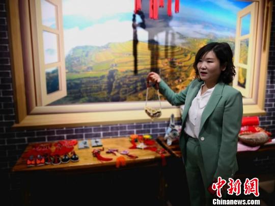 图为甘肃酒泉“创业妹”邓世贤介绍农村妇女们的手工艺品。　闫姣 摄
