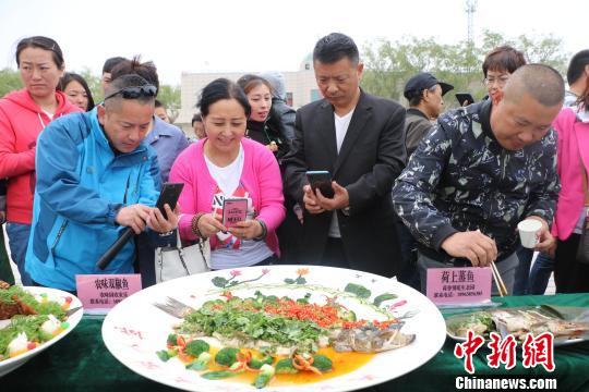 博湖县乌兰再格森乡“乌兰美食”全鱼宴，香引八方游客，用博湖味道唤醒了这个湖畔乡村的记忆。　王陆斌 摄