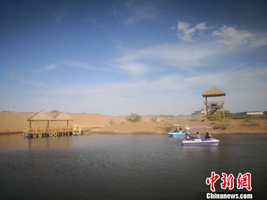 图为游客在大漠中“游山玩水”。　魏建军 摄