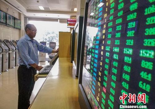 资料图：海口某证券公司营业部的股民关注股市动态。/p中新社记者 骆云飞 摄