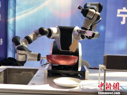 双臂协作机器人正在模拟炒菜颠勺动作。　潘沁文 摄