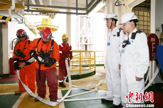 图为海事港口国监督检查官(右)检查船员消防技能 。海南海事局 供图