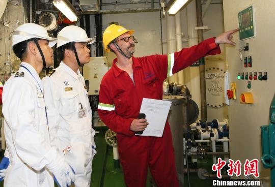 图为海事港口国监督检查官(左)检查防污染设备运行情况。海南海事局 供图