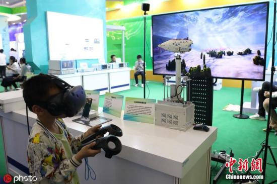 5月19日至5月26日，以“科技强国科普惠民”为主题的2019年全国科技活动周暨北京科技周在中国人民革命军事博物馆举办。图为5月21日，北京军事博物馆，2019北京科技周ZTE中兴展区，参观者体验5G远程控制潜水艇。图片来源：ICphoto