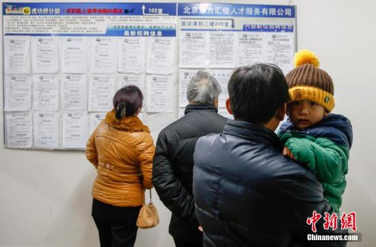 2月11日，北京市虎坊桥人才市场内，一名抱着孩子的应聘者正在观看招聘信息，大厅内求职者的数量与招聘人员的数量不相上下。春节过后，这里的招聘求职信息主要集中在餐饮行业。一名招工者说，求职者中一些人不具备相关的专业技能，但是对于比较低端的工作也不愿从事，就出现了招工难和求职难并存的现象。/p中新社发 张浩 摄