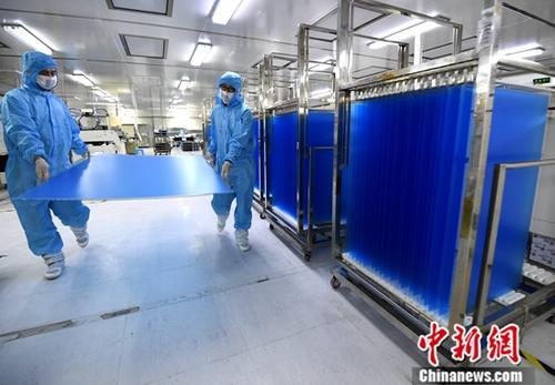 资料图：福建省连城县中触电子有限公司工人在车间搬运刚生产出来的大尺寸触摸屏产品。/p中新社记者 张斌 摄
