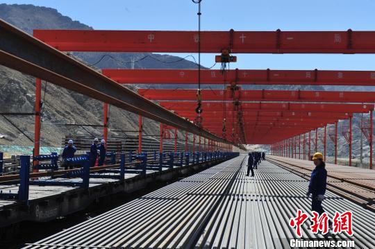 取消企业银行账户许可后，企业资金周转效率进一步提升，有利于优化营商环境。图为西藏拉林铁路正在进行超长钢轨吊装。(资料图) 江飞波 摄