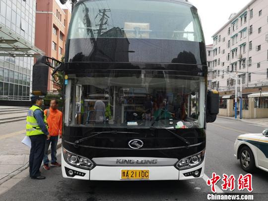 执法人员对一辆客车进行执法检查。 供图