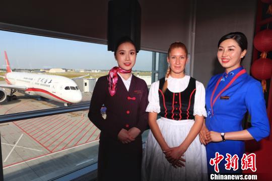 上航乘务员与身穿民族服装的工作人员合影留念。