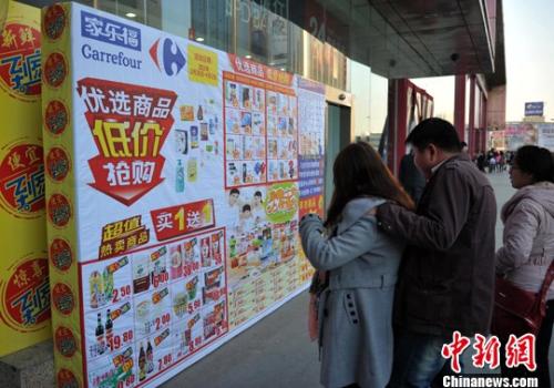 资料图：家乐福超市为吸引人气打起了促销牌。 胡影 摄 