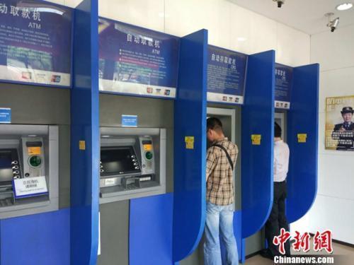 资料图：民众在自动取款机上取钱。/p中新网记者 李金磊 摄